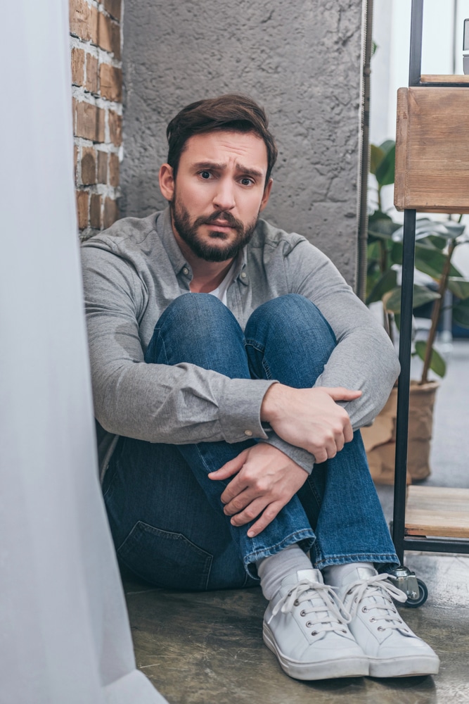 anxious and strung out guy sitting on the ground wondering How Long Does Meth Stay in Your System?