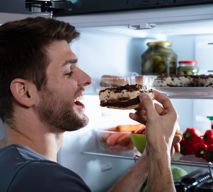 party drugs made this young man very hungry so he's eating from the fridge late night
